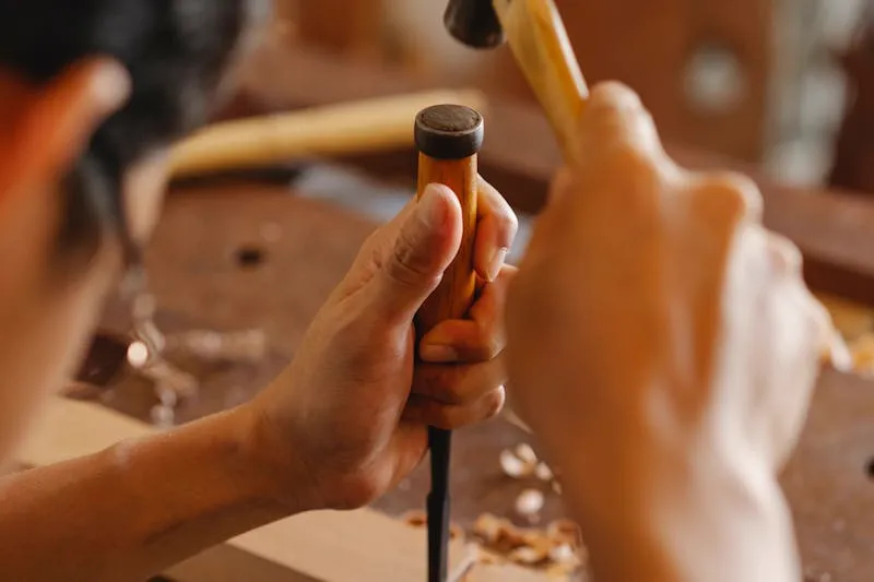 Chisel cutting a hinge mortise into a door frame