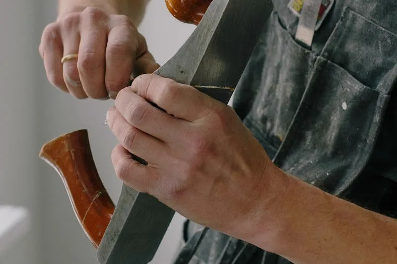 Block plane removing a thin shaving from the edge of a sticking door